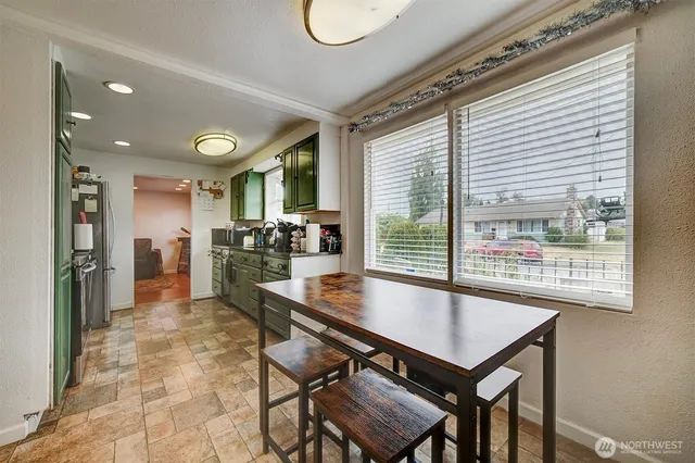 a kitchen with a table chairs refrigerator and cabinets