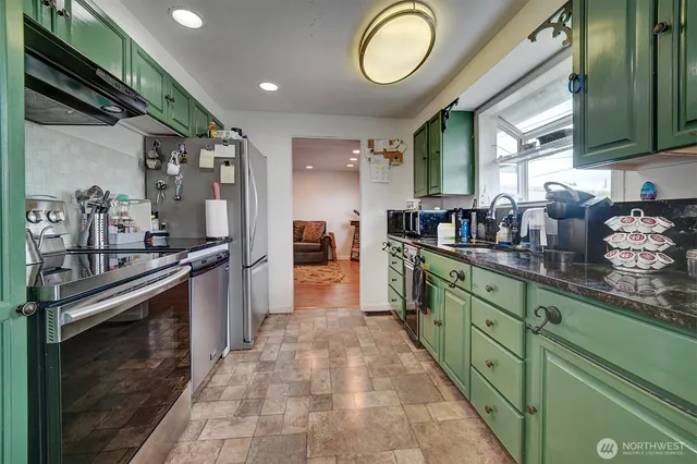 a kitchen with stainless steel appliances granite countertop a sink and cabinets
