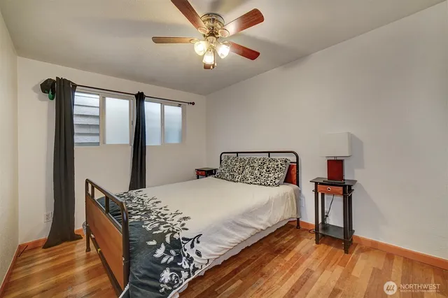 a bedroom with a bed and a dresser next to a window