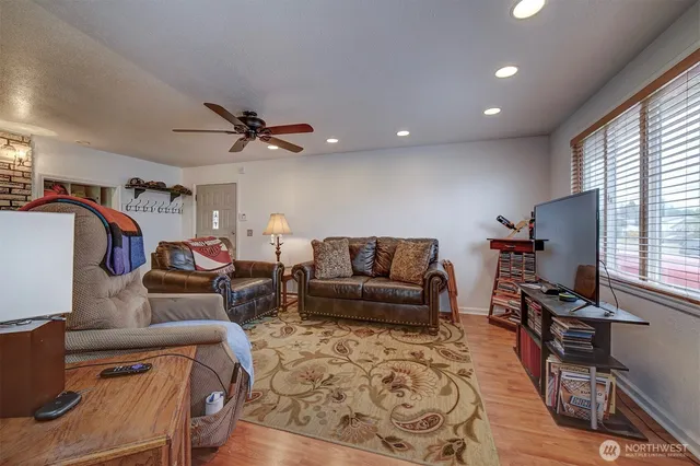 a living room with furniture ceiling fan and a window