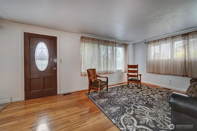 a living room with furniture a rug a lamp and a window