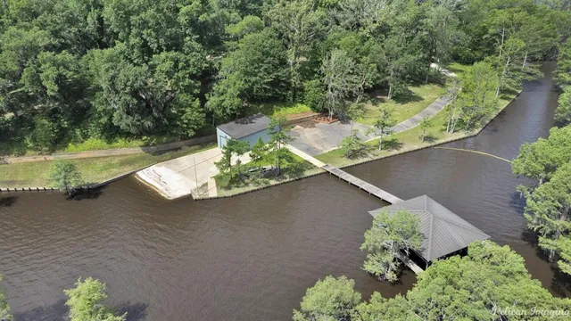 an aerial view of a house with a yard and lake view