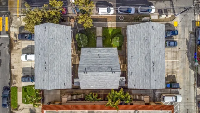 an aerial view of residential houses with outdoor space and parking