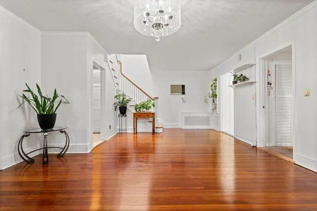 a view of a living room with wooden floor and stairs