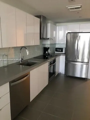 a kitchen with stainless steel appliances granite countertop a refrigerator and a stove top oven