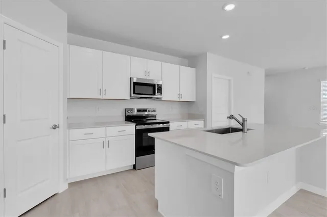 a kitchen with white cabinets and stainless steel appliances