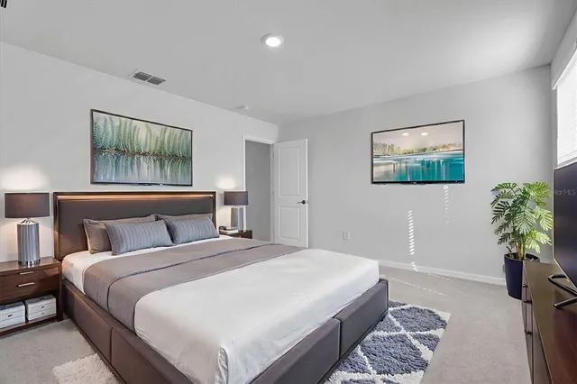 a bedroom with bed and a painting on the wall