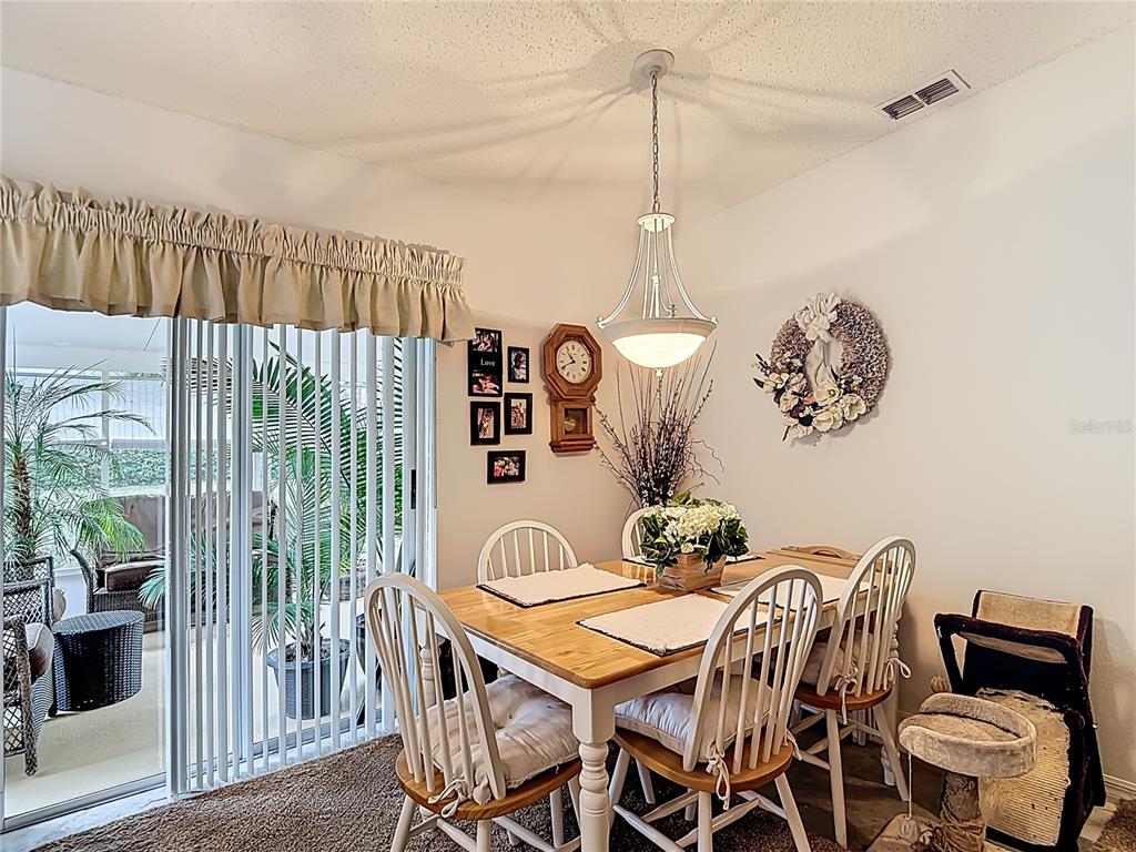 11034 Cranston Street Spring Hill, FL 34608 - Photo 11 of 40 a dining room with furniture a chandelier and window