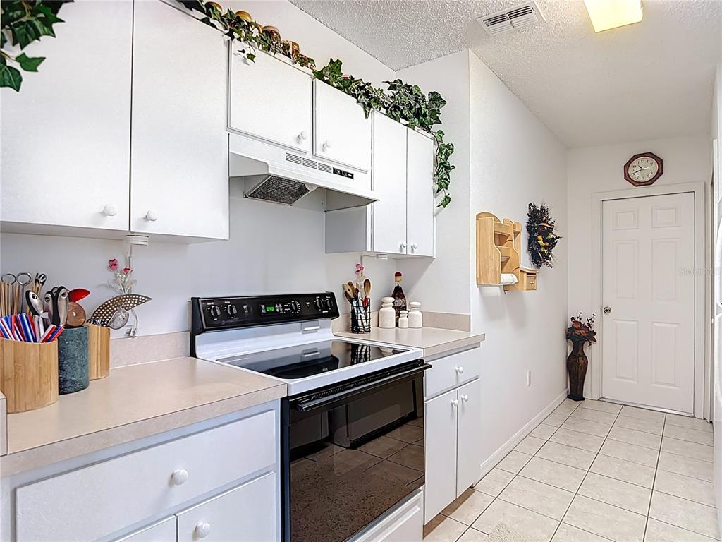 11034 Cranston Street Spring Hill, FL 34608 - Photo 13 of 40 a kitchen with stainless steel appliances granite countertop a sink a stove and a refrigerator