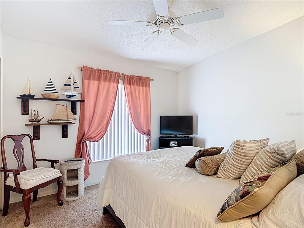 11034 Cranston Street Spring Hill, FL 34608 - Photo 21 of 40 a bedroom with a bed and a chandelier