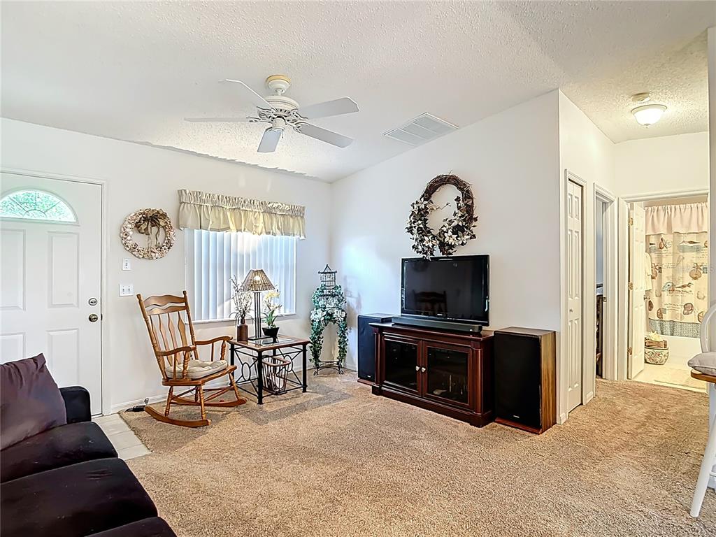 11034 Cranston Street Spring Hill, FL 34608 - Photo 9 of 40 a living room with furniture a fireplace and a flat screen tv