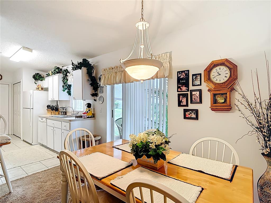 11034 Cranston Street Spring Hill, FL 34608 - Photo 10 of 40 a kitchen with granite countertop a table and chairs