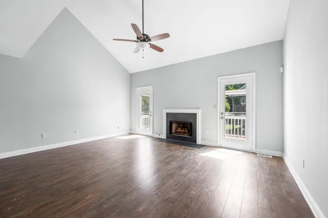 a view of empty room with fireplace and wooden floor