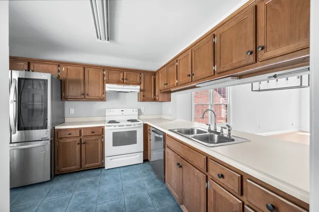 a kitchen with stainless steel appliances a stove a sink and a refrigerator