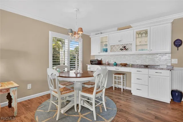 a kitchen with granite countertop stainless steel appliances a stove a table and chairs in it