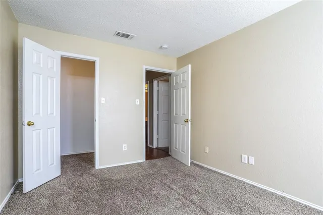 a view of an empty room with closet and a window