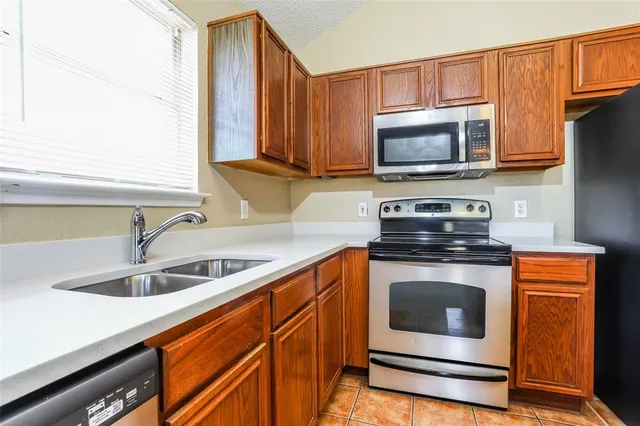 a kitchen with stainless steel appliances granite countertop a sink stove and microwave