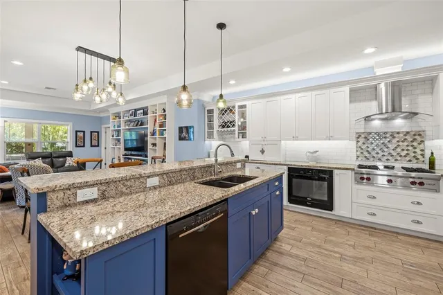 a kitchen with stainless steel appliances granite countertop a stove a sink and a wooden cabinets
