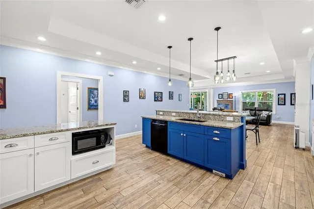 a kitchen with stainless steel appliances granite countertop wooden floors and white cabinets