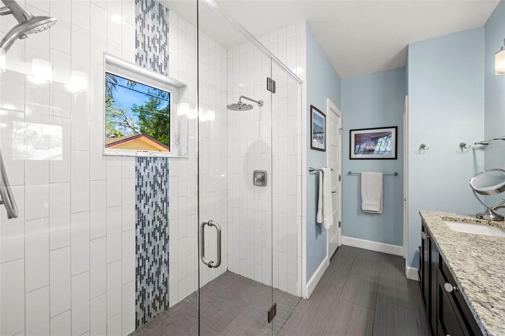 2623 57th Street South Gulfport, FL 33707 - Photo 25 of 50 a bathroom with a granite countertop shower a sink and a painting