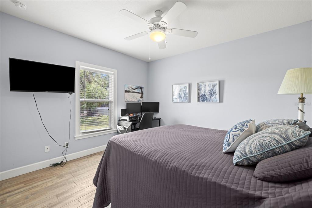 2623 57th Street South Gulfport, FL 33707 - Photo 27 of 50 a bedroom with a bed a couch and a flat screen tv