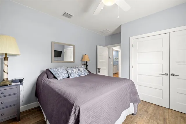 a bedroom with a bed and a lamp on dresser