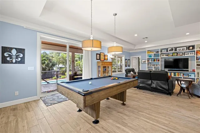 a living room with furniture a flat screen tv and floor to ceiling window