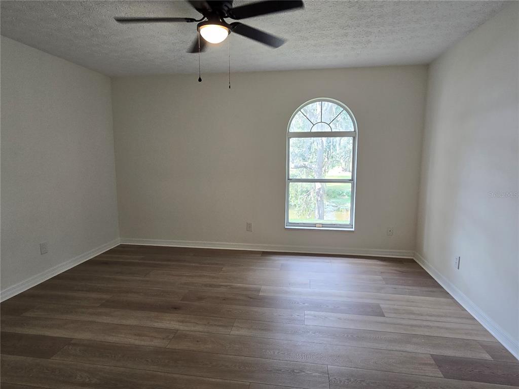 719 Balmoral Court Inverness, FL 34453 - Photo 14 of 29 an empty room with wooden floor fan and windows