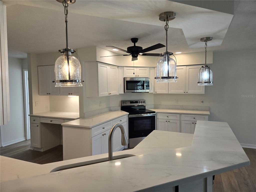 719 Balmoral Court Inverness, FL 34453 - Photo 6 of 29 a kitchen with stainless steel appliances granite countertop a sink a stove and a wooden floors