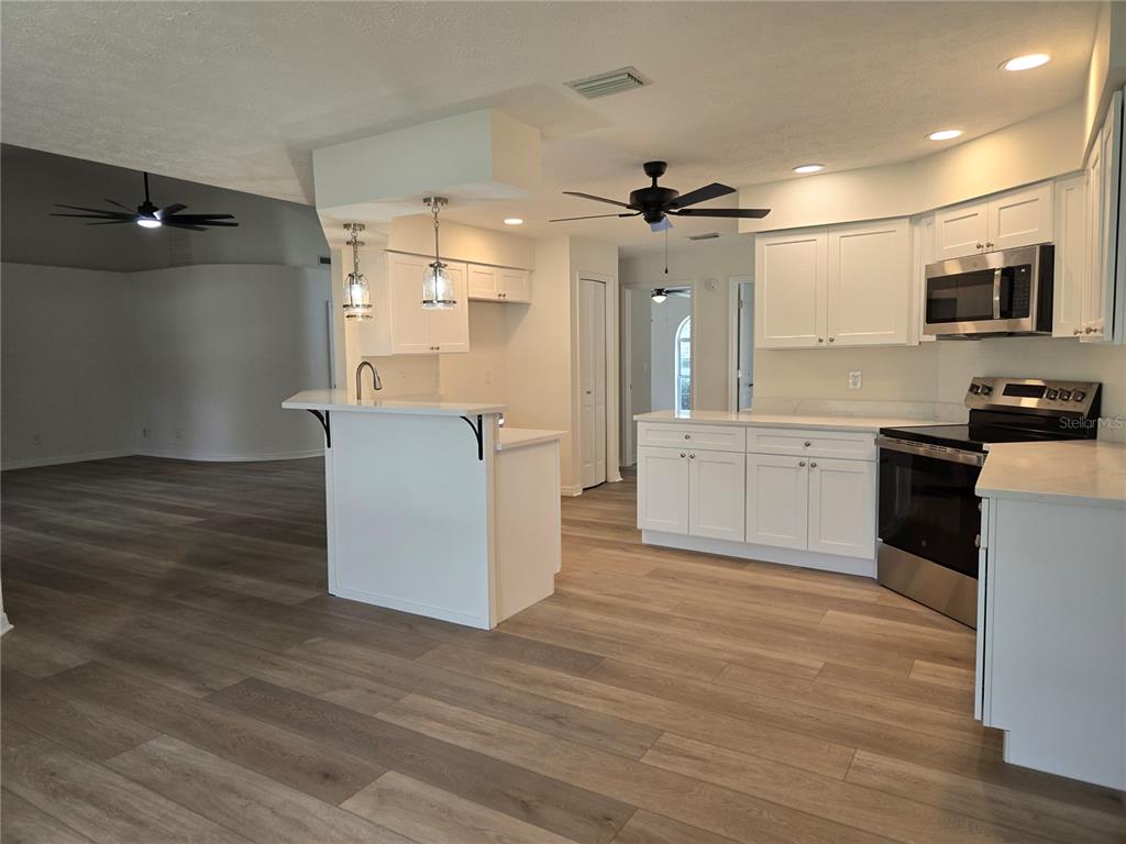 719 Balmoral Court Inverness, FL 34453 - Photo 9 of 29 a large kitchen with cabinets and wooden floor