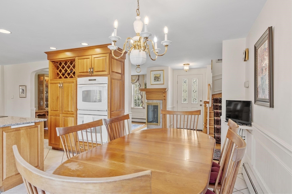 103 Brooks Station Road Princeton, MA 01541 - Photo 12 of 42 a dining room with wooden floor a chandelier a glass table and chairs
