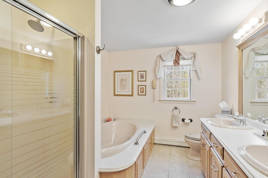 103 Brooks Station Road Princeton, MA 01541 - Photo 28 of 42 a bathroom with a granite countertop sink a mirror a bathtub and next to a window