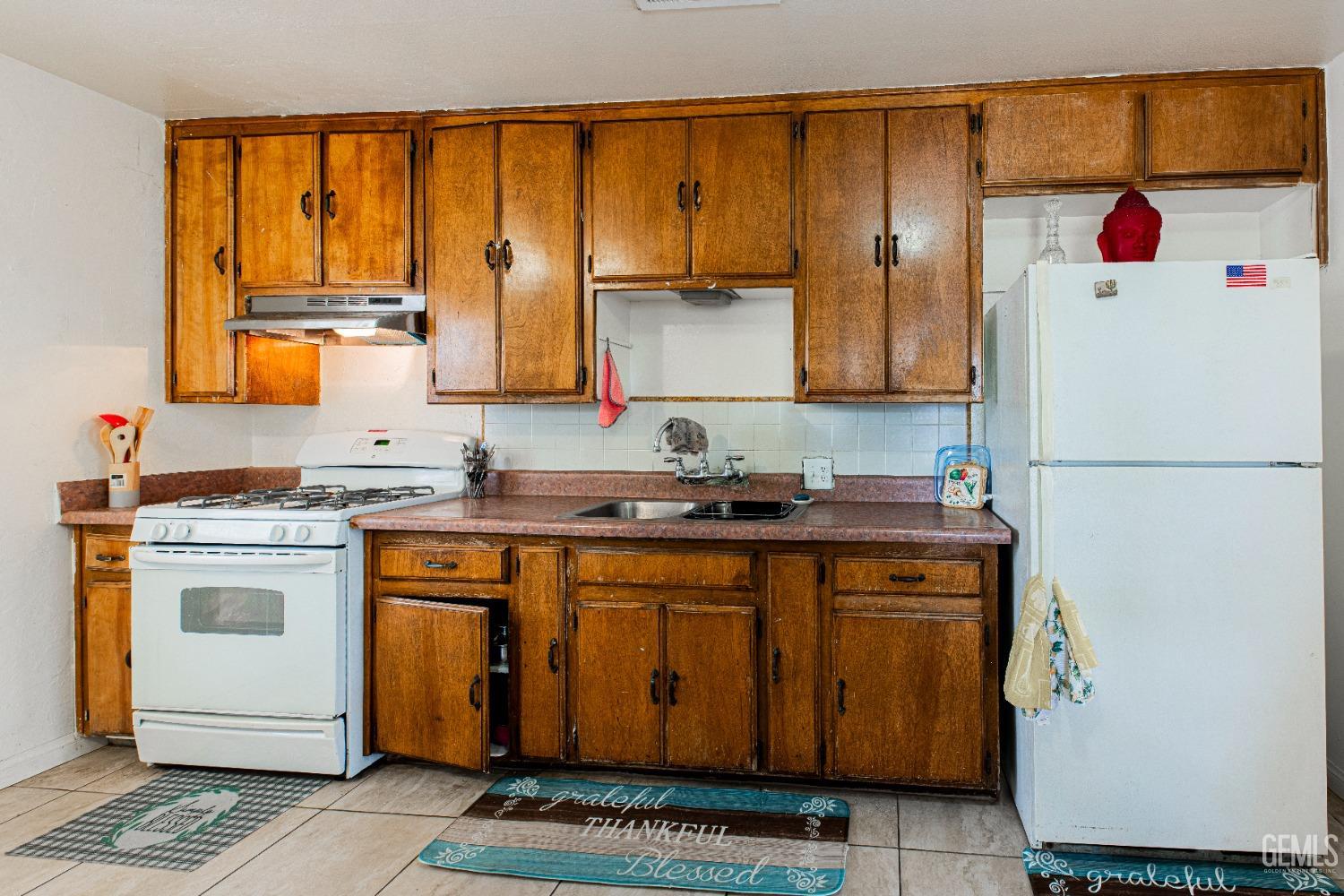 Undisclosed Address Bakersfield, CA 93307 - Photo 13 of 27 a kitchen with a refrigerator and a sink