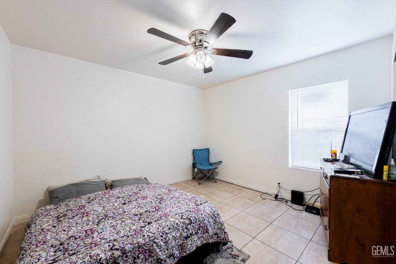 Undisclosed Address Bakersfield, CA 93307 - Photo 14 of 27 a bedroom with a bed and a chandelier