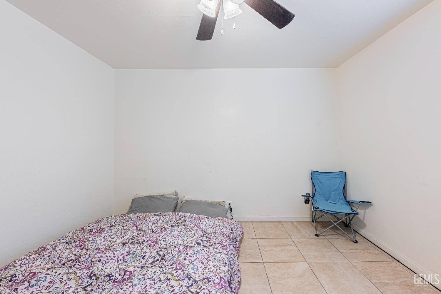 Undisclosed Address Bakersfield, CA 93307 - Photo 15 of 27 a room that has a bed and a chair in it