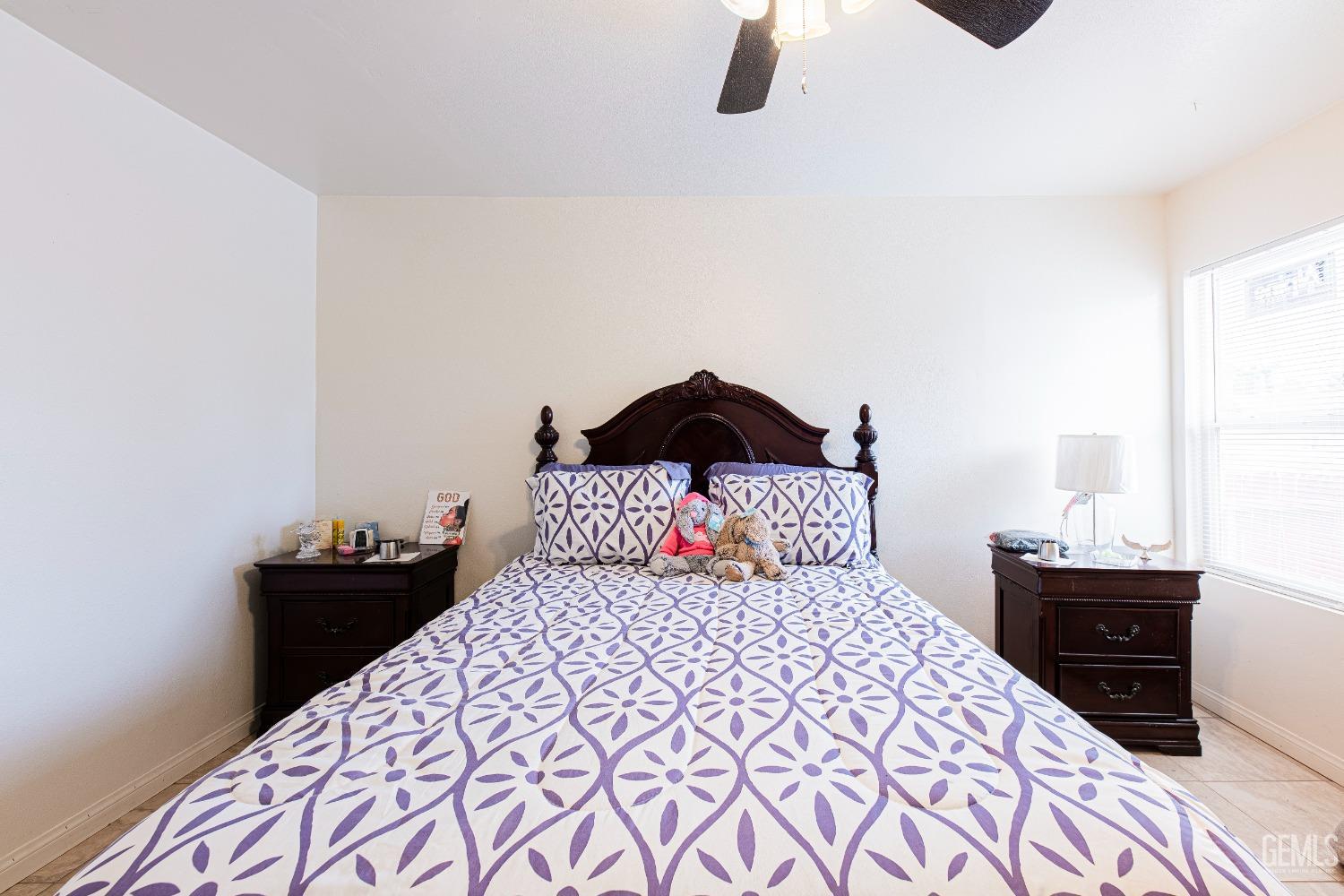 Undisclosed Address Bakersfield, CA 93307 - Photo 18 of 27 a bedroom with a bed and a lamp on dresser