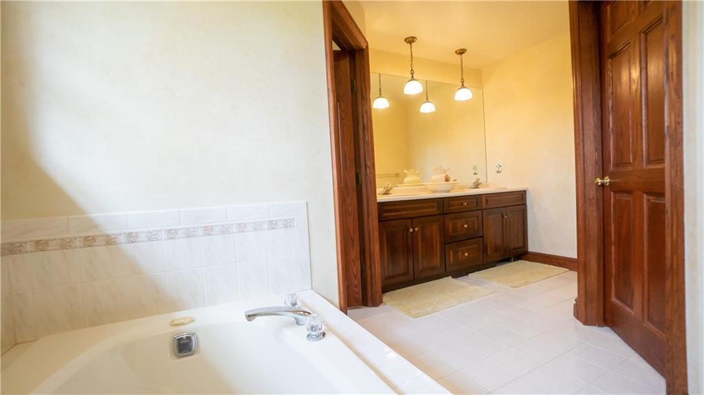 7034 Forrest Trail Road Butler, PA 16002 - Photo 21 of 25 a bathroom with a tub sink shower and mirror