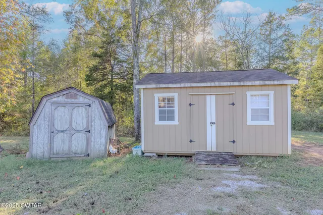 a backyard of house with a space and wooden fence