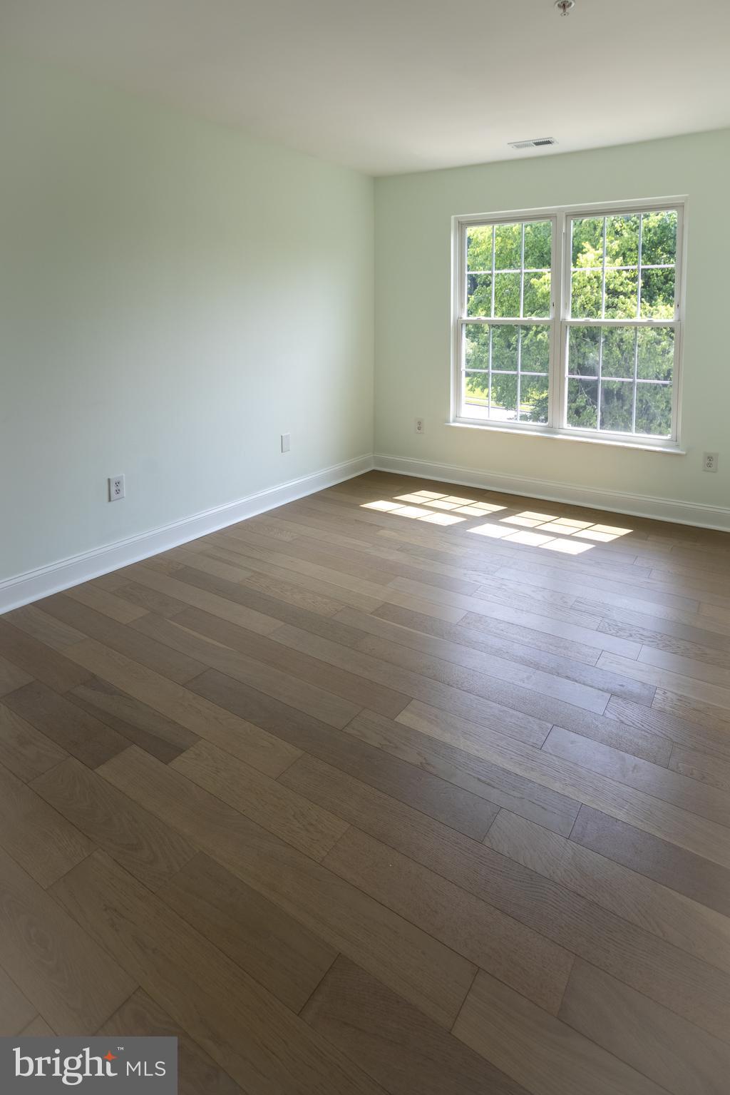 11904 White Heather Road Cockeysville, MD 21030 - Photo 24 of 42 an empty room with wooden floor and windows