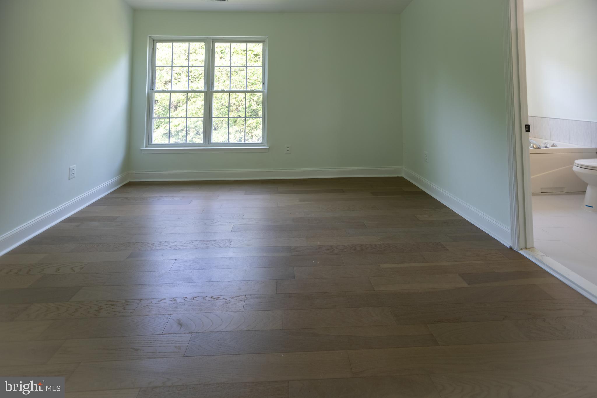 11904 White Heather Road Cockeysville, MD 21030 - Photo 32 of 42 an empty room with wooden floor and windows