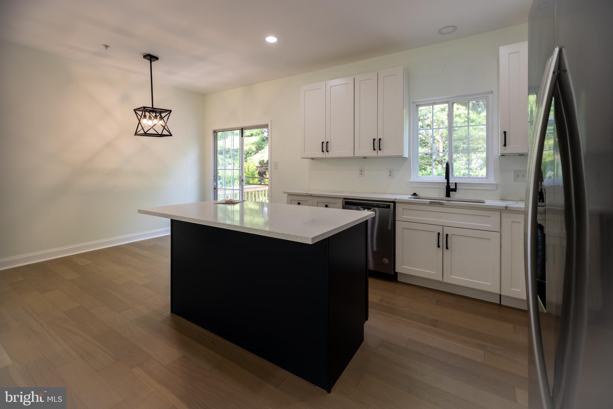 11904 White Heather Road Cockeysville, MD 21030 - Photo 10 of 42 a kitchen with kitchen island granite countertop a sink cabinets and wooden floor