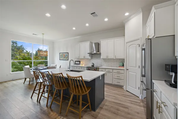 a kitchen with a table chairs refrigerator and microwave