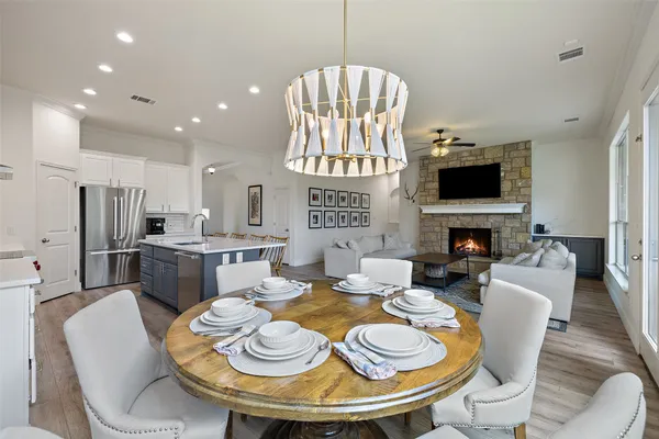 a dining room with furniture a fireplace and a chandelier