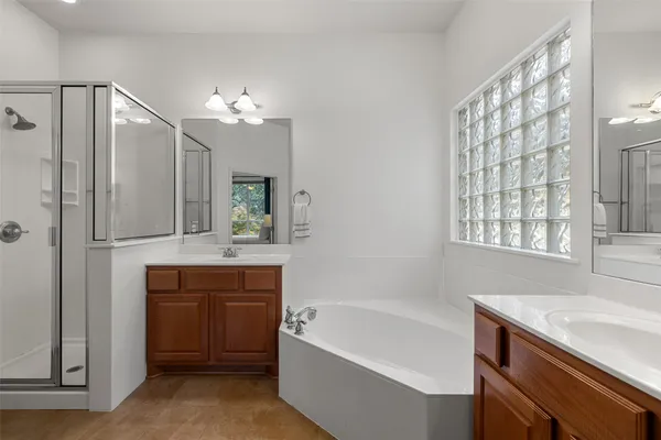 a bathroom with a bathtub a sink and a large mirror