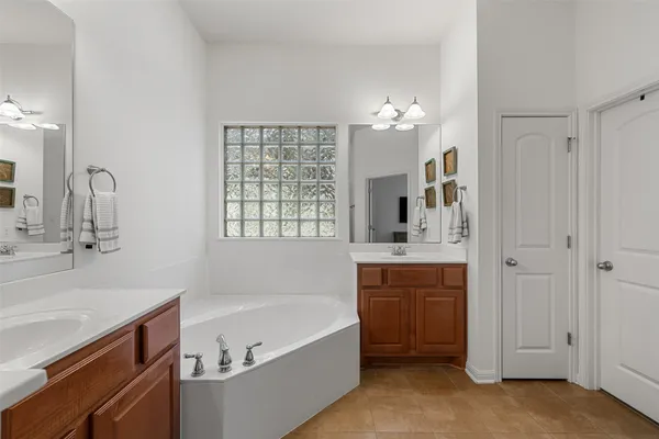a bathroom with a tub sink and mirror
