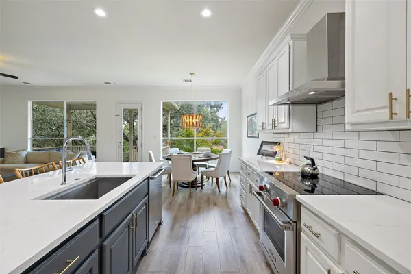 a kitchen with lots of counter top space a sink appliances and cabinets