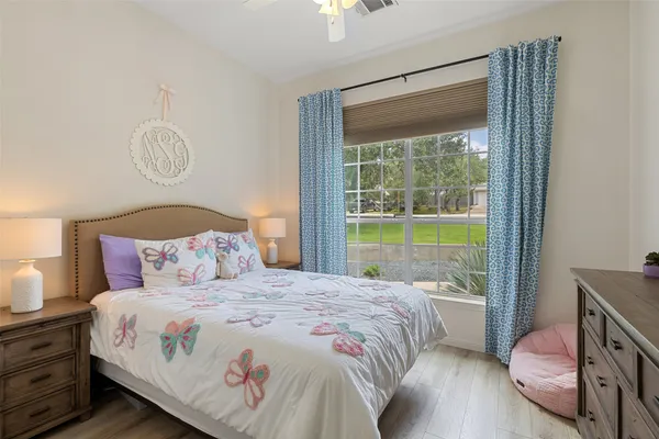 a bedroom with a bed a chandelier and a window