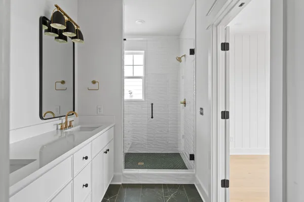 a bathroom with a shower sink and mirror