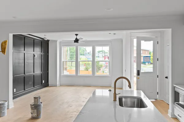 a kitchen with a faucet a chandelier and living area