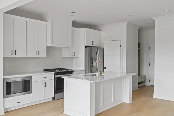 a kitchen with appliances a sink and cabinets